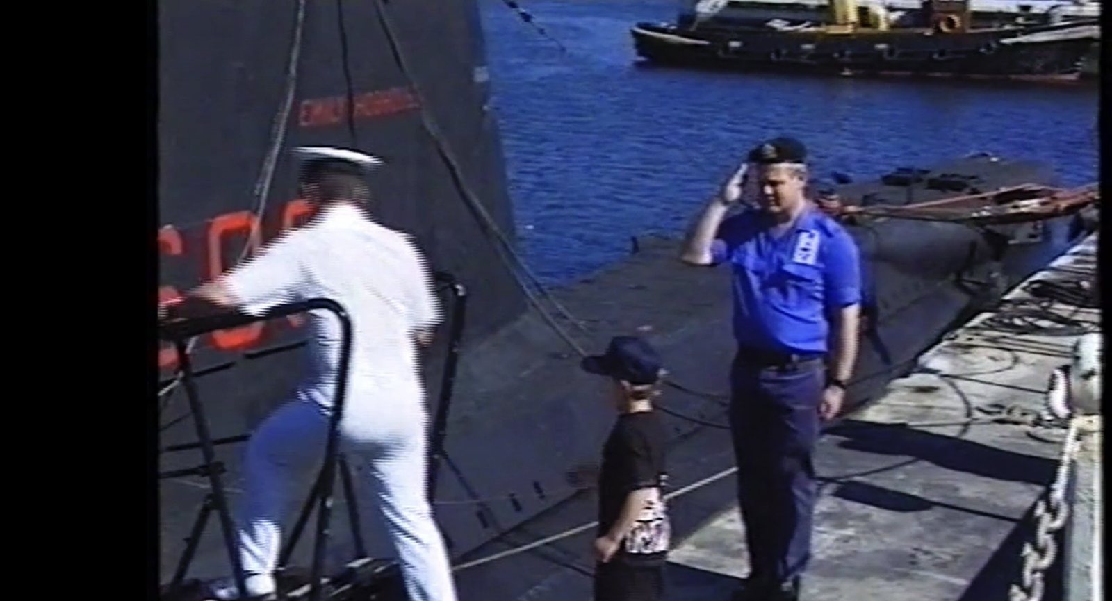 A naval officer saluting Chris beside the submarine