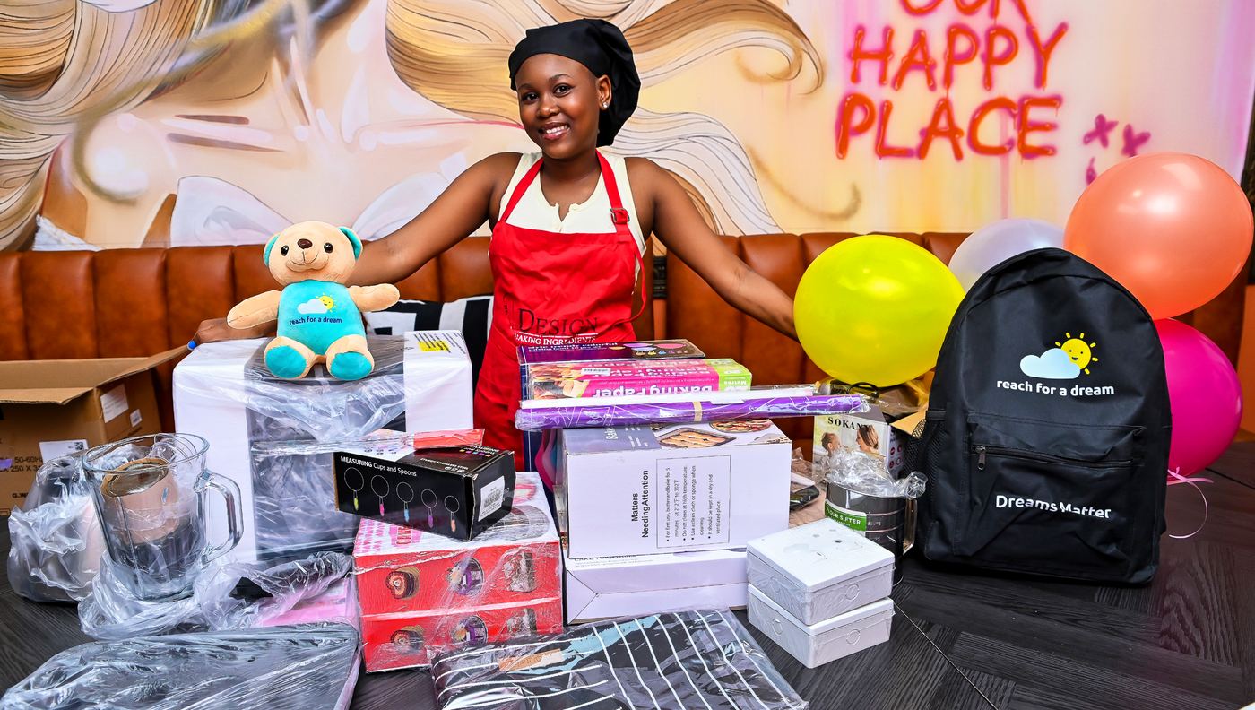 A young baker in apron and chef's hat behind a table of new baking equipment