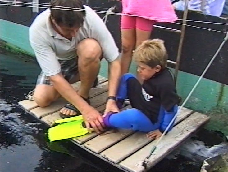 Chris as a boy being helped into flippers on a jetty at Simonstown